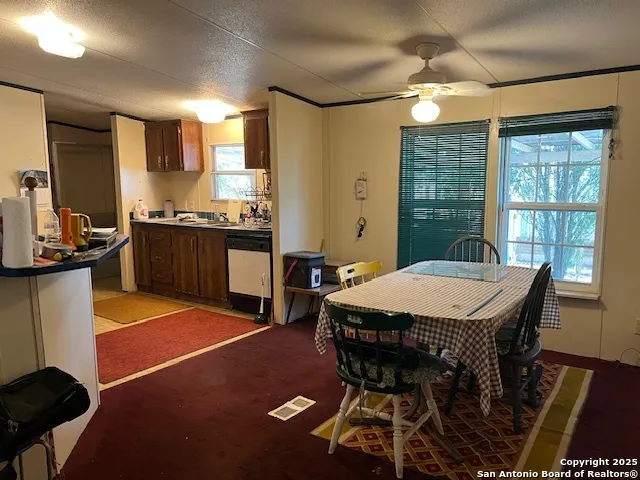 a kitchen with stainless steel appliances granite countertop a stove top oven a sink a dining table and chairs with wooden floor