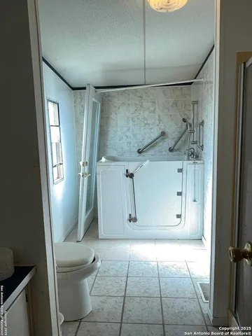 a bathroom with a granite countertop shower and a toilet