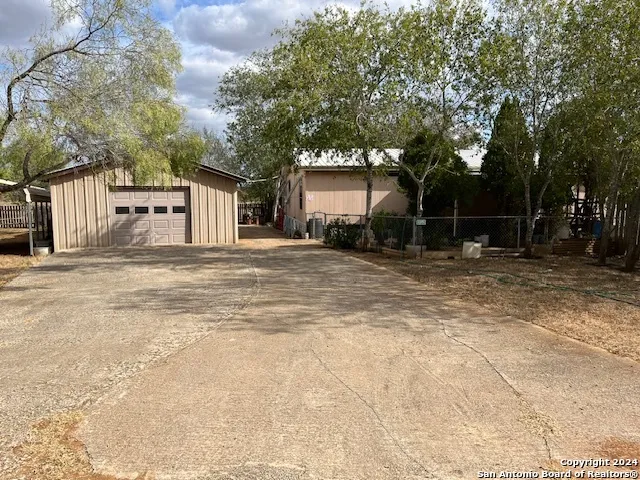 a backyard of a house with large trees and brick walls
