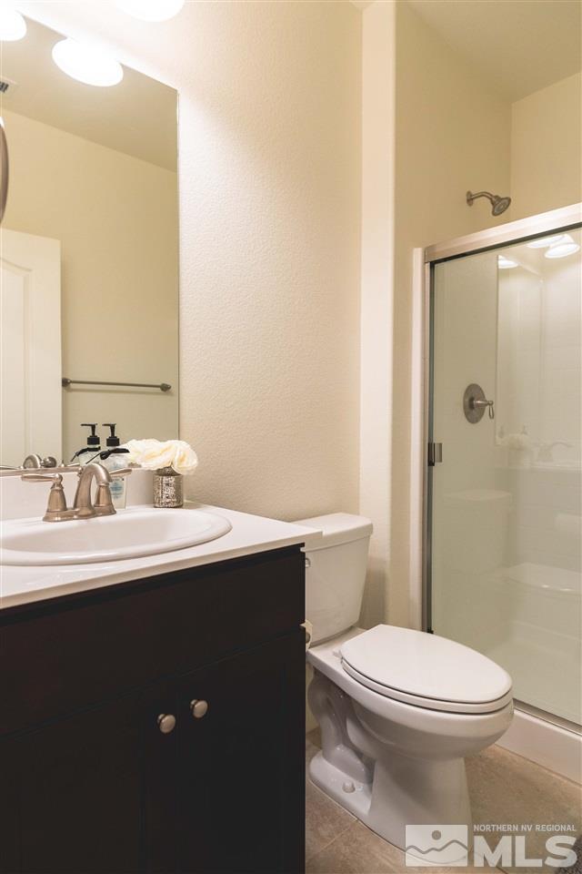 9746 Pachuca Drive Reno, NV 89521 - Photo 11 of 25 a bathroom with a sink a toilet a mirror and shower