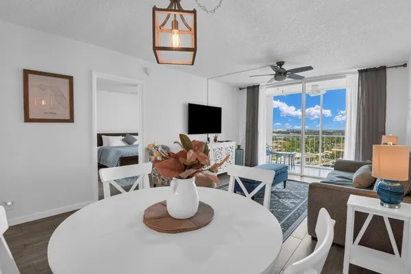 a living room with furniture a flat screen tv and a floor to ceiling window