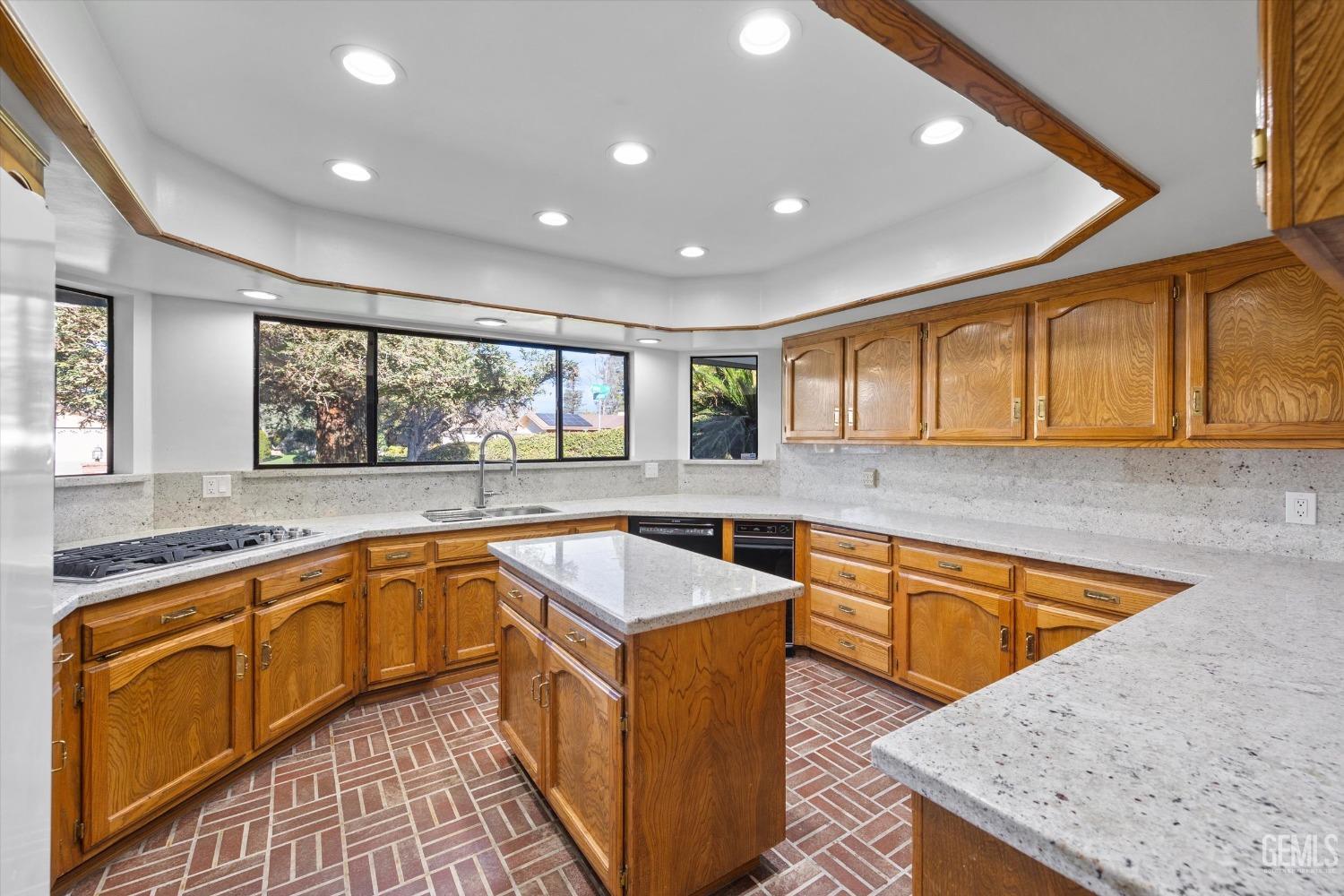 Undisclosed Address Bakersfield, CA 93312 - Photo 12 of 49 a kitchen with wooden cabinets sink and granite counter top