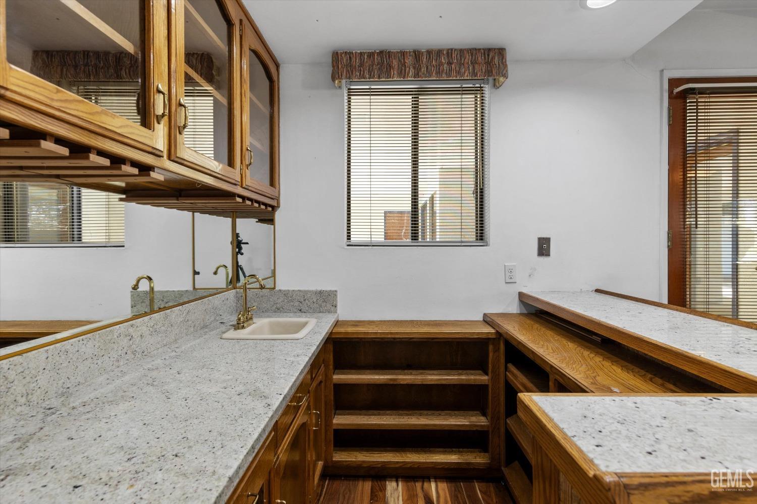 Undisclosed Address Bakersfield, CA 93312 - Photo 14 of 49 a bathroom with a granite countertop sink and mirror