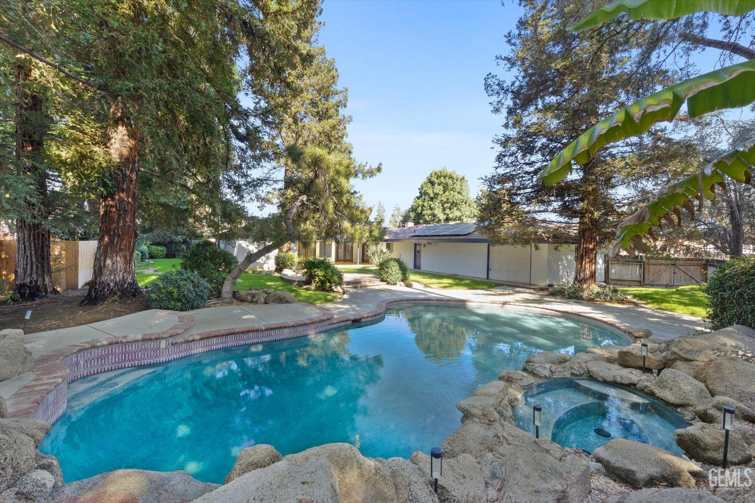 Undisclosed Address Bakersfield, CA 93312 - Photo 34 of 49 a backyard of a house with table and chairs and a large tree