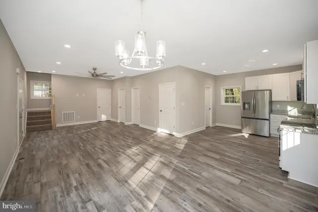 a kitchen with granite countertop a stove top oven and refrigerator