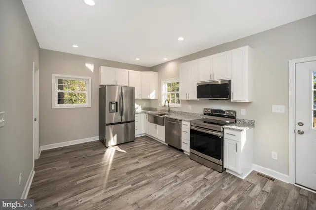 a kitchen with stainless steel appliances white cabinets and a refrigerator