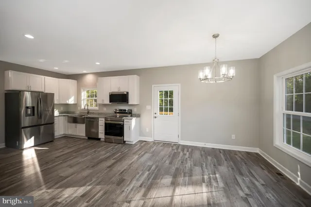 a kitchen with granite countertop a stove a sink and a refrigerator