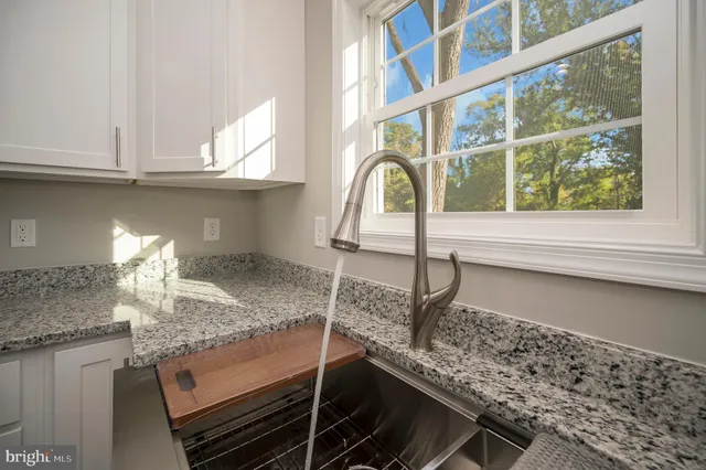 a bathroom with a granite countertop sink a toilet a mirror and bathtub