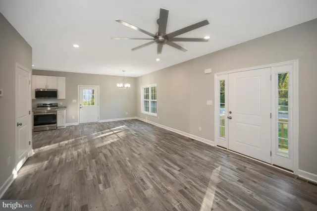 a view of kitchen with granite countertop stainless steel appliances and wooden floor