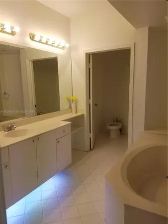 a spacious bathroom with a bathtub sink and mirror