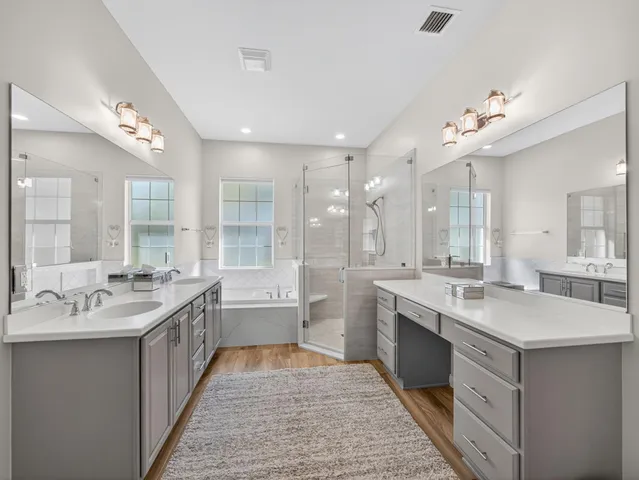 a large bathroom with a double vanity sink a large mirror and a bathtub