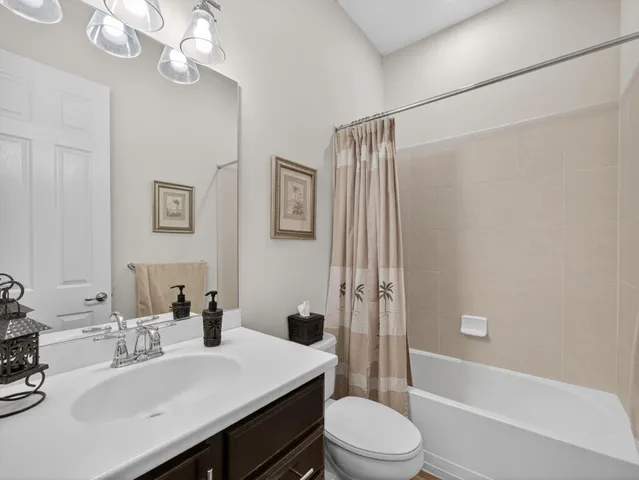 a bathroom with a sink a toilet a mirror a vanity and shower