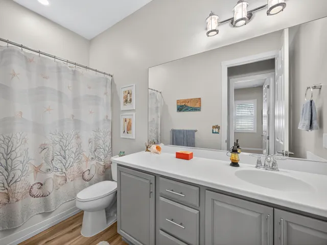 a bathroom with a sink a toilet and shower curtain