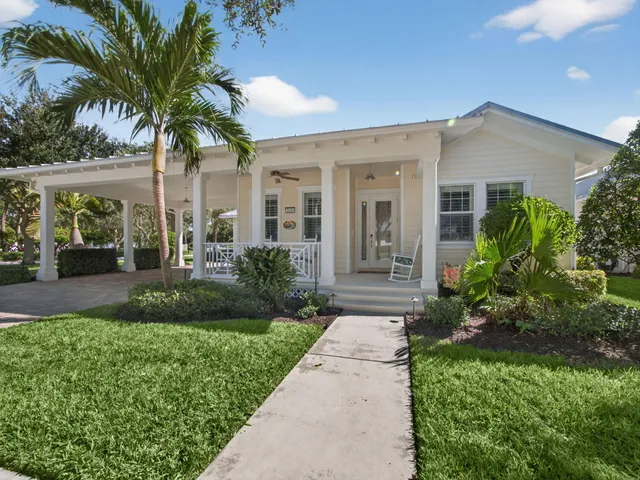 front view of a house with a yard and potted plants