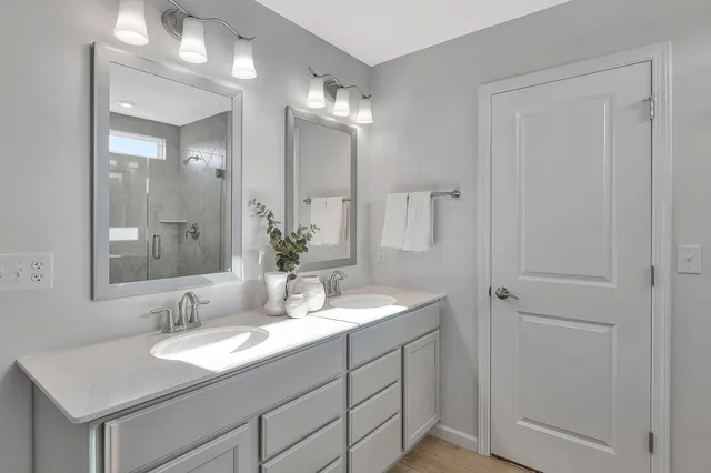 a bathroom with double sink and a mirror
