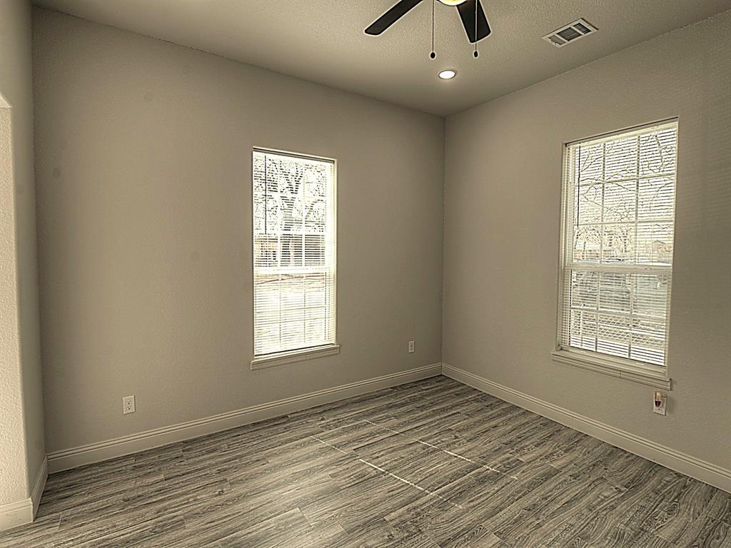 605 Olive Street Cleburne, TX 76031 - Photo 12 of 40 a view of an empty room with wooden floor and a window