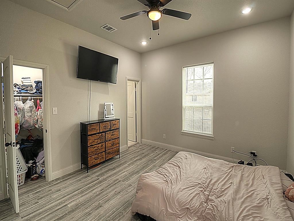 605 Olive Street Cleburne, TX 76031 - Photo 16 of 40 a bedroom with a bed and a flat screen tv