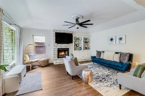 a living room with furniture a flat screen tv and a fireplace