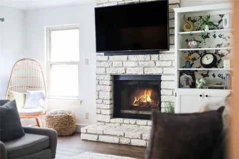 a living room with furniture a flat screen tv and a fireplace