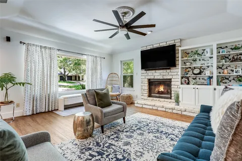 a living room with furniture a flat screen tv and a fireplace