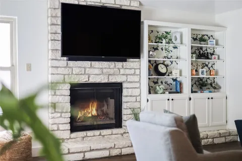 a living room with a fireplace and a flat screen tv