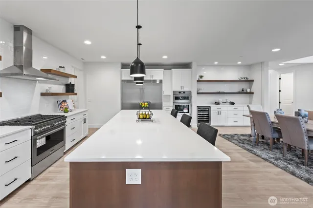 a kitchen with stainless steel appliances kitchen island granite countertop a sink a stove and a refrigerator