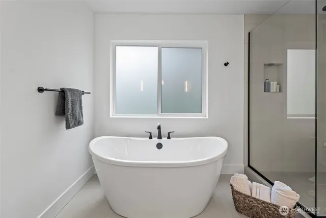a white bath tub sitting next to a bathroom sink