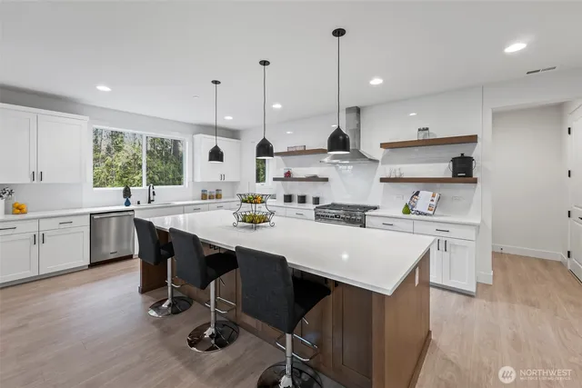 a kitchen with kitchen island a sink a stove a center island and a window