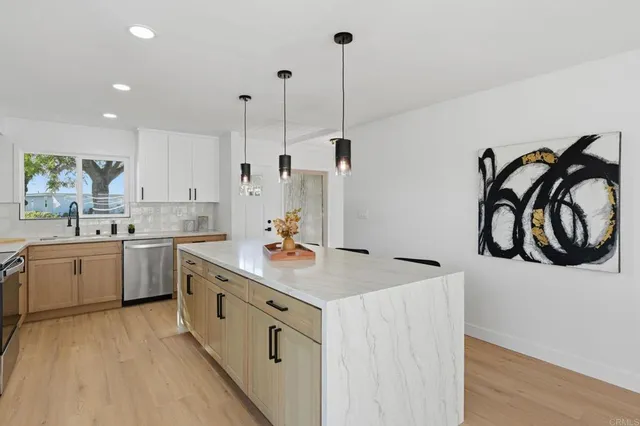 a kitchen with white cabinets appliances and a wooden floor