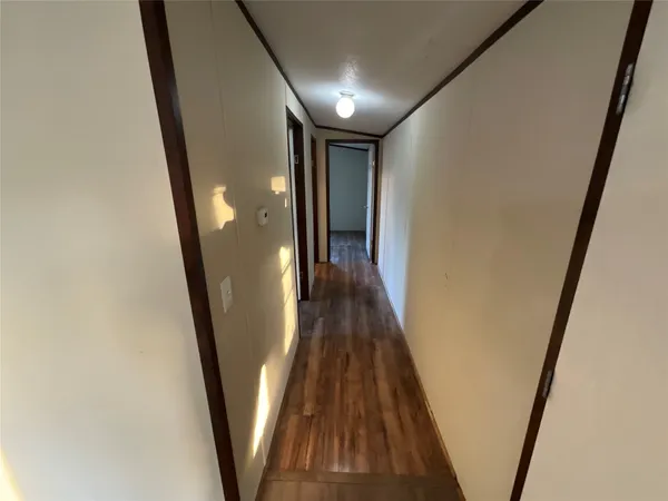 a view of a hallway with wooden floor and stairs