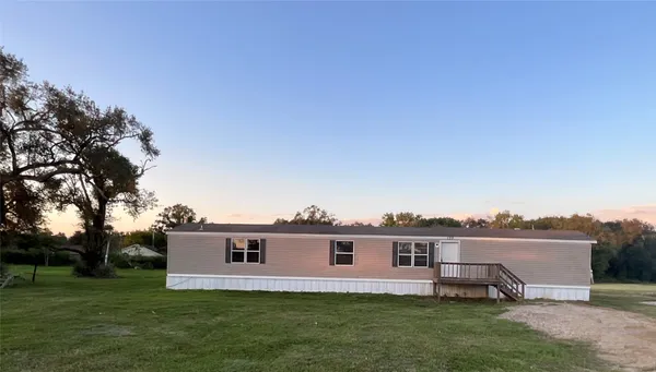 a view of a house with a yard and sitting area