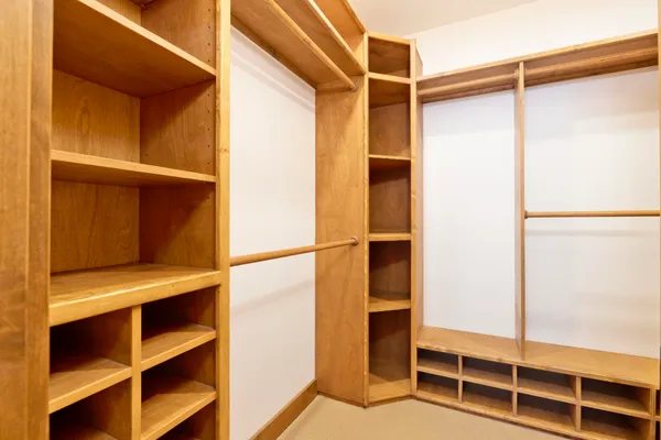 a view of walk in closet with empty racks