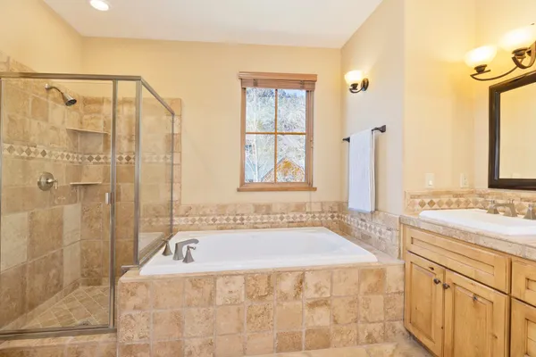 a bathroom with a tub sink and mirror