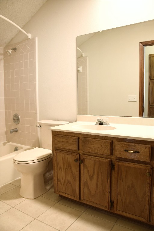 1911 Klattenhoff Drive Austin, TX 78728 - Photo 11 of 14 Full bathroom with vanity, shower / tub combination, light tile patterned floors, lofted ceiling, and a textured ceiling
