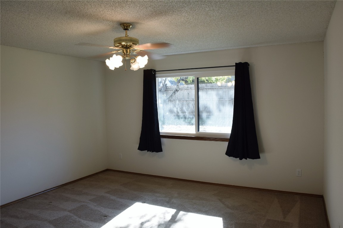1911 Klattenhoff Drive Austin, TX 78728 - Photo 7 of 14 Unfurnished room featuring carpet flooring, a textured ceiling, and ceiling fan