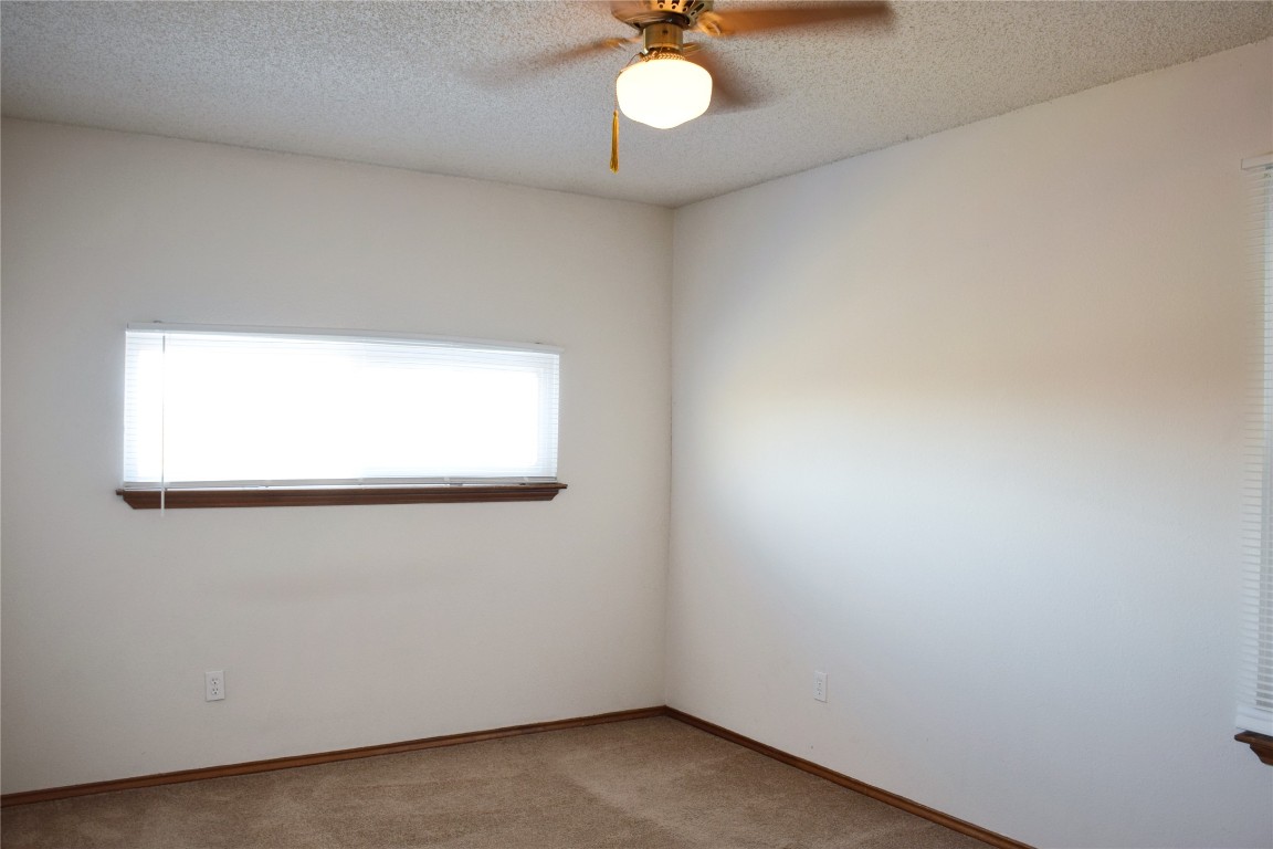 1911 Klattenhoff Drive Austin, TX 78728 - Photo 10 of 14 Spare room with a textured ceiling, carpet, and ceiling fan