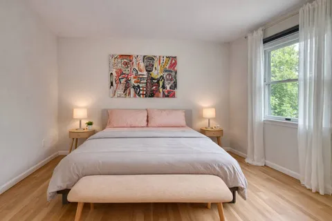 a bedroom with a bed and a painting on the wall