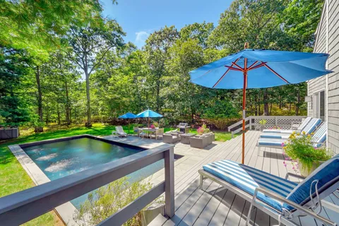 a view of swimming pool with chairs and umbrella