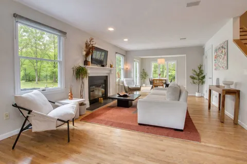 a living room with furniture fireplace and a large window