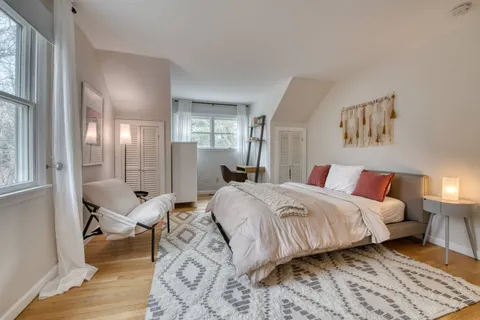a bedroom with a bed and wooden floor