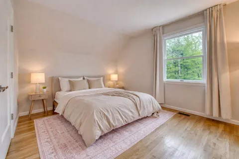a bedroom with a bed and wooden floor