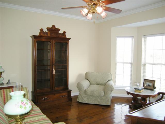 The formal living room or office has a bay window with a beautiful view of the lush acreage.