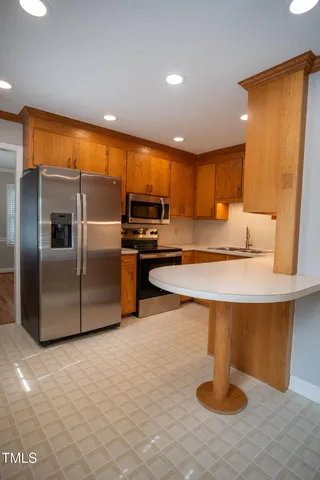 a kitchen with stainless steel appliances granite countertop a sink and a refrigerator
