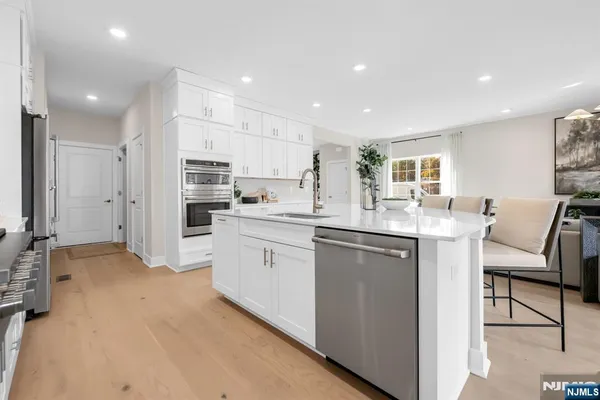 a kitchen with white cabinets and refrigerator