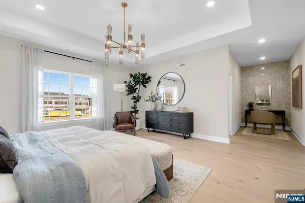 a bedroom with a large bed and a chandelier