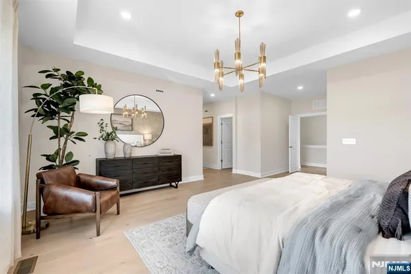 a bedroom with a bed a chandelier and a mirror