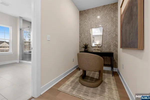 a view of a hallway with wooden floor and a mirror