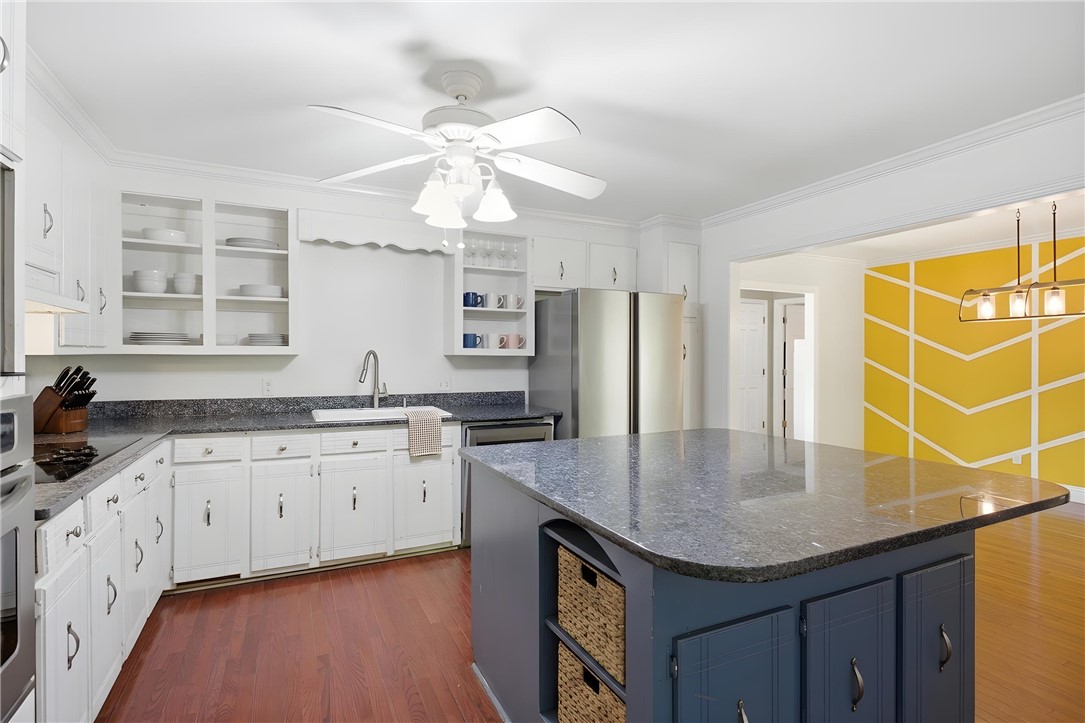 311 Cumberland Way Anderson, SC 29621 - Photo 7 of 44 A vibrant kitchen space showcases a practical island with ample counter space and warm hardwood flooring.