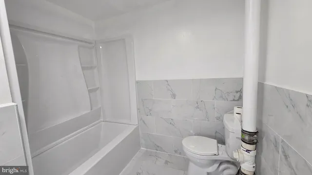 a bathroom with a granite countertop toilet a sink and bathtub