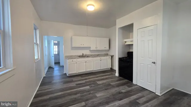 a view of a kitchen with a white cabinets and wooden floor